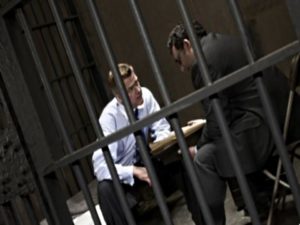 Адвокат по уголовным делам разговаривает с клиентом в СИЗО
